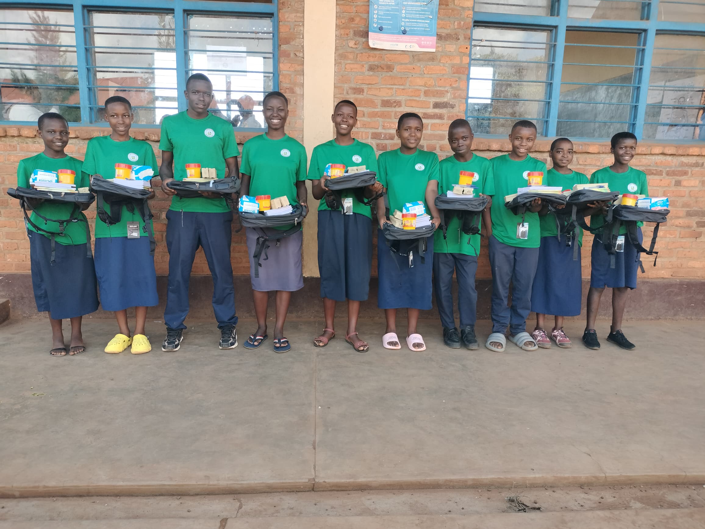 Smiling children receiving new school uniforms.
